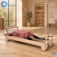 Reformer de Pilates en bois d'érable rose poussiéreux avec rail fixe, barre de repose-pieds intégrée et support à ressorts réglable pour les cours de bien-être