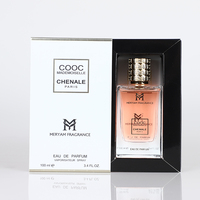 Parfum féminin, flacon rectangulaire en verre transparent, liquide rose, capuchon doré à nervures, boîte à ruban, parfum floral aux pétales