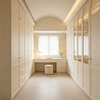 Villa élégante de style italien, bureau de maquillage intégré en MDF couleur crème, armoire-penderie avec porte vitrée cintrée du sol au plafond.