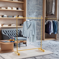 Présentoir pliable moderne et personnalisable en acier inoxydable doré brillant pour vêtements de magasin de détail, idéal pour les boutiques de prêt-à-porter féminin et les usines.
