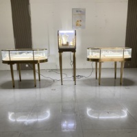 Vitrine à bijoux ovale de luxe en acier inoxydable avec éclairage LED doré, verre incurvé, couleur personnalisable, design durable pour comptoir d'îlot