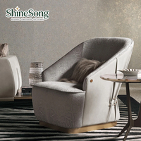 Fauteuil individuel moderne haut de gamme en tissu de luxe avec détails rivetés, base dorée, mobilier design pour salon et villa