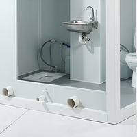 Cabine de toilettes portable avec deux postes séparés, évier central et structure en panneaux sandwich EPS