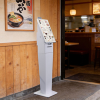 Kiosco de autoservicio con pantalla táctil para pedidos y pagos en restaurantes, con base estable anticaídas.
