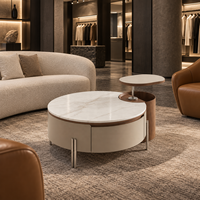 Table basse relevable WYRAX pour hall d'hôtel avec plateau supérieur surélevé, plateau latéral ouvert et base de rangement incurvée