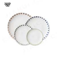 Séduisant ensemble d'assiettes en porcelaine Motifs artistiques multicolores à bords de points pour des paramètres de table de mariage mémorables