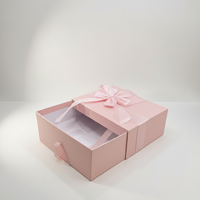 Stabile Geschenkbox im Schubladenstil mit Schleifenband, handgefertigt von einem Architekturstudio, raffiniertes rosa Etui für Bekleidung.