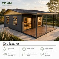 Maison conteneur TDHH à toit en pignon avec porche à baldaquin, balustrade en verre, terrasse et fenêtres à auvent