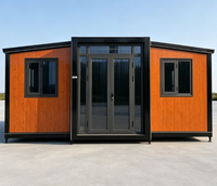 Maison préfabriquée extensible en conteneur, structure noire, panneaux imitation bois, double porte vitrée, installation rapide, maisonnette modulaire