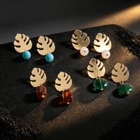 Boucles d'oreilles créoles motif feuille tropicale, en laiton artisanal, design ajouré, avec feuilles de bambou évoquant une coquille de tortue et pierres turquoise. Oreille
