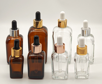Flacon compte-gouttes carré en verre ambré vide de 10 ml avec anneau doré et bulbe en caoutchouc noir, pour huiles essentielles et cosmétiques, opaque, vente en gros
