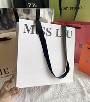 Sac de shopping en papier cartonné de luxe recyclable personnalisé avec poignée longue pour boutique de vêtements, emballage cadeau
