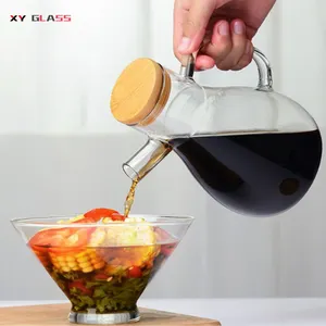 La cucina domestica sfusa usa una bottiglia di olio da cucina olivia in vetro trasparente con salsa di soia