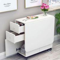 Une combinaison simple d'une table et de chaises qui peuvent être pliées en une table basse rectangulaire avec une armoire de rangement