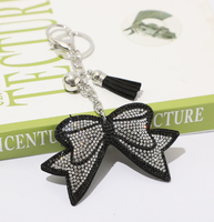 Koningsblauwe modieuze sleutelhanger met zwarte achtergrond, strikvorm, volledig bezet met strass steentjes en kwastjes, best verkochte charme hangende ornament