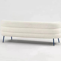 Chaise longue incurvée blanche en bouclette, fauteuil avec rembourrage moelleux, accoudoirs à niveaux, pieds en bois, design moderne pour salon et hôtel