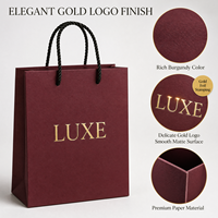 Sac cadeau en papier bordeaux de luxe avec logo en feuille d'or, poignées en corde torsadée renforcées, artisanat exquis