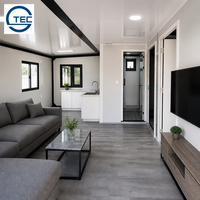 Maison conteneur préfabriquée modulaire extensible portable à double porte vitrée avec finition grain de bois et double fenêtre