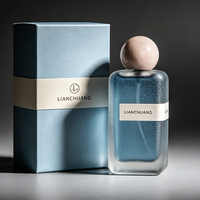 Flacon de parfum vide rectangulaire long givré bleu brumeux à paillettes, avec bouchon boule rose nude, plaque nominative blanche, logo personnalisé et coffret cadeau