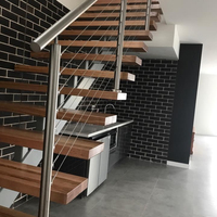 Escalier intérieur moderne à monopoutre avec garde-corps en câble et marches en bois massif