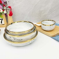 Service de vaisselle de luxe en porcelaine à bord doré pour 12 personnes, comprenant des bols, des assiettes à dessert et des assiettes à dîner en céramique.
