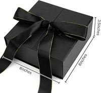 Boîte cadeau pliable magnétique noire mate avec ruban en satin noir à bords dorés, emballage rigide pliable
