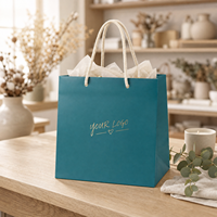 Sacs cadeaux en papier bleu sarcelle avec logo personnalisé KM, poignée en corde de coton crème, cœur en feuille d'or, pour boutique et vente au détail