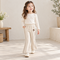Pantalon évasé ivoire pour filles avec applique champignon, bordure de jambe en zigzag et poches latérales pour collections de vêtements pour enfants en gros et sur mesure
