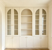 Bibliothèque de style français sur mesure, armoire de présentation intégrée blanc crème avec portes en verre cintrées et armoires de rangement solides