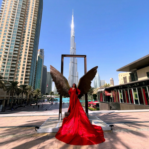 Elegante sesión de fotos con vestido rojo en Dubái, con icónicas alas escultóricas y una vista majestuosa del Burj Khalifa en el fondo - Product Image 1
