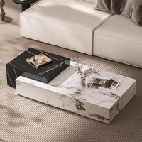 Table basse contemporaine noire et blanche rectangulaire avec plateau en pierre et rangement caché pour ensemble de canapés.