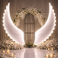 Décor de scène de mariage avec ailes d'ange illuminées, arche en cage à oiseaux, présentoir événementiel, design personnalisé
