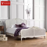 Lit double de luxe de style américain en bois massif, finition bois ciré blanc, avec tête de lit rembourrée en osier et motifs sculptés à la française