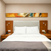 Ensemble de mobilier moderne pour chambre double d'hôtel : lit avec tête de lit capitonnée en placage de bois, chevet et fauteuil de détente
