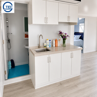Maison conteneur préfabriquée modulaire extensible portable à double porte vitrée avec finition grain de bois et double fenêtre