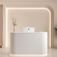 Comptoir de réception de salon de beauté incurvé en MDF blanc avec logo gravé personnalisé rétroéclairé par LED