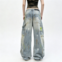 Jean long en denim style rétro américain, coupe courbée, effet vieilli et déchiré avec trous, peint avec des graffitis colorés