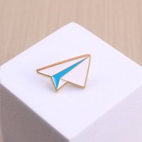 Broche en émail élégante et simple avec un design d'avion en papier, adaptée aux personnes soucieuses de la mode dans une esthétique minimaliste.
