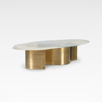 Table basse en verre organique de luxe avec base en laiton brossé pour les intérieurs de salon contemporains