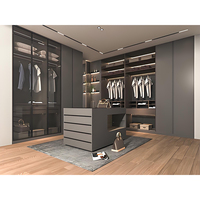 Dressing de luxe sur mesure en L avec portes vitrées, étagères ouvertes en bois, îlot central et éclairage LED intégré pour chambre à coucher