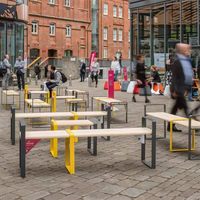 Ensemble table et bancs en fer forgé de style classique pour extérieur, idéal pour restaurant, espace commercial, place publique, aménagement paysager et sièges publics