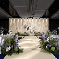 Décoration complète de salle de mariage incluant des boules de fleurs, des décorations de plafond, des lumières de guidage allant au sol, des fleurs artificielles pour la décoration de scène