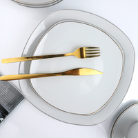 Vente en gros d'assiettes blanches en vrac de haute qualité, assiettes rondes en porcelaine en céramique, assiettes irrégulières de restaurant avec bordure dorée