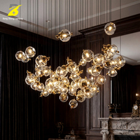 Lustre LED artistique en boules de verre - Suspension cascade dorée pour hall d'hôtel et atrium