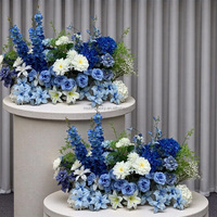 Vente en gros pour mariage : Composition florale de 70 cm pour allée de mariage, avec rangée de fleurs en soie bleues, champagne et rouges, et roses blanches
