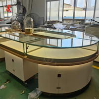 Luxuriöses Rundes Schmuck-Präsentationsinsel-Set Gebogene Glasvitrine mit LED-Beleuchtung Gebürstetes Gold Boutique-Einzelhandelsmöbel