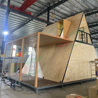 Cabane triangulaire en structure acier avec terrasse, double étage, aspect bois, chalet de luxe pour complexe hôtelier, maison préfabriquée