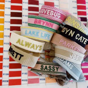 Pulseras al por mayor personalizadas con logo y texto, estilo bohemio, con cinta, letras bordadas, borlas y tejido religioso. - Product Image 1