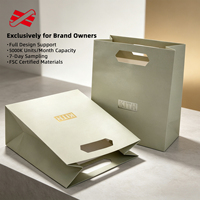 Sac en papier vert sauge personnalisé avec poignée découpée et logo en feuille d'aluminium pour les commandes en gros de magasins de style de vie