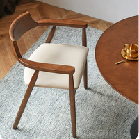 Chaise de salle à manger nordique en chêne massif avec dossier courbé et accoudoirs, et coussin en mousse haute densité amélioré, idéale pour les restaurants